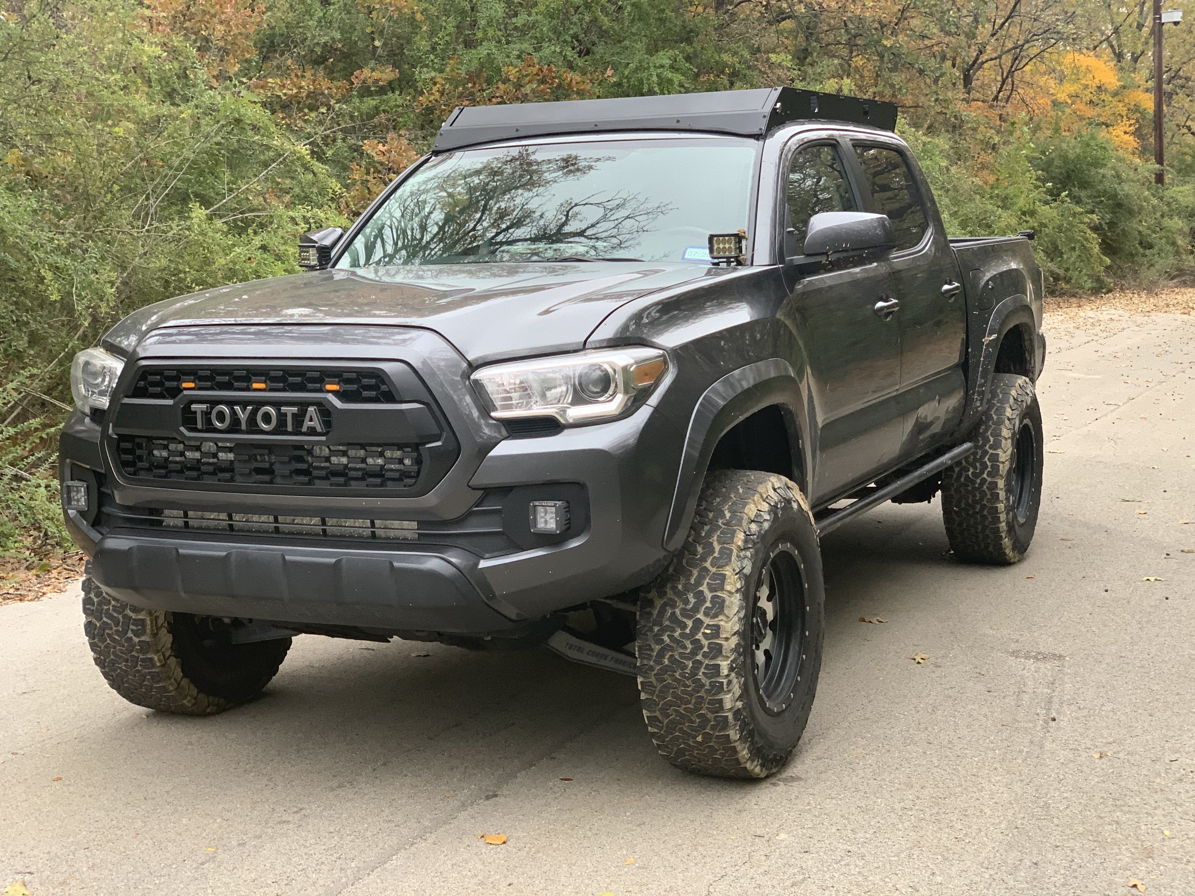 Front drivers side view of gray Toyota Tacoma with Premium roof rack - Cali Raised LED