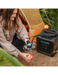 RinseKit Cube portable shower rinsing apple at campsite near tent
