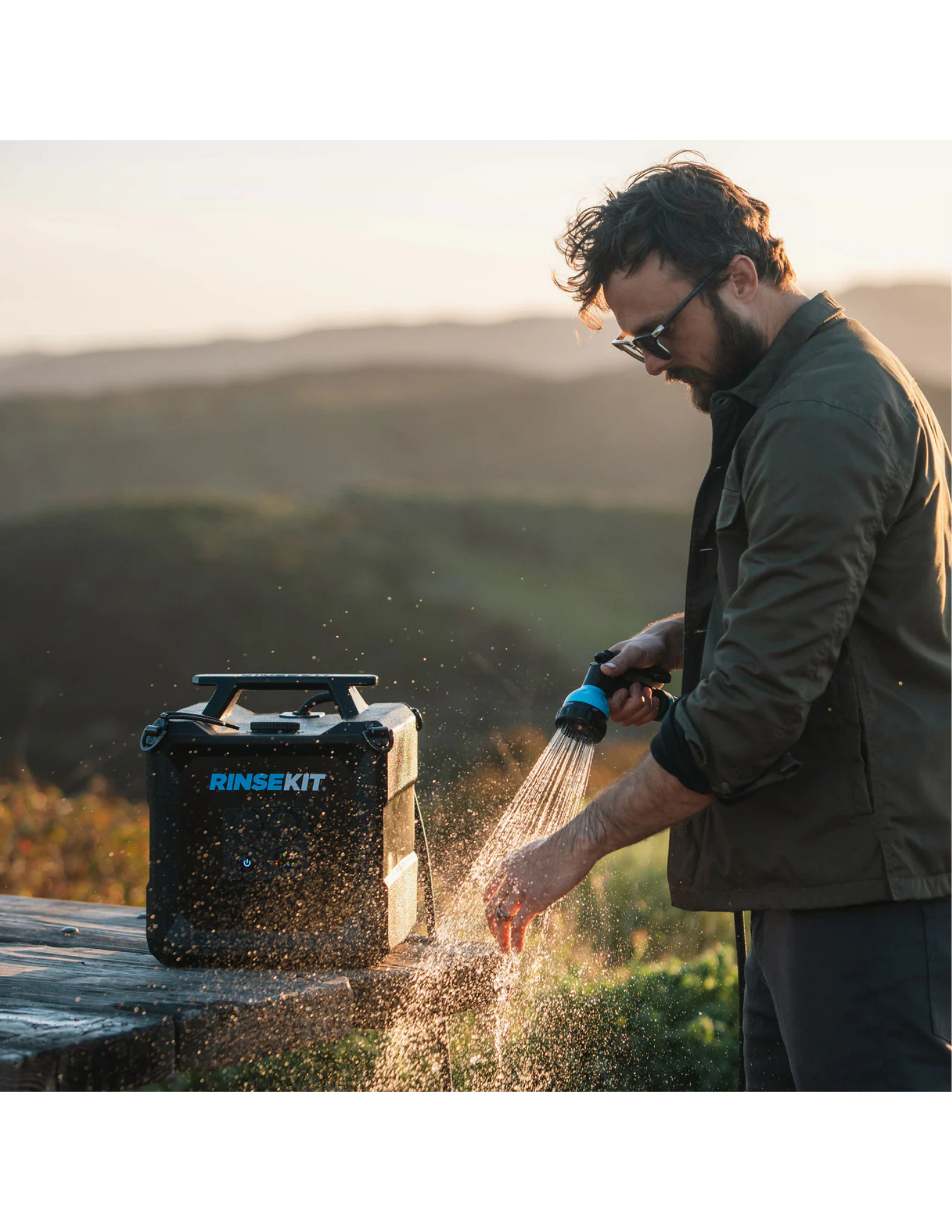 RinseKit Cube portable shower used for hand washing at outdoor campsite