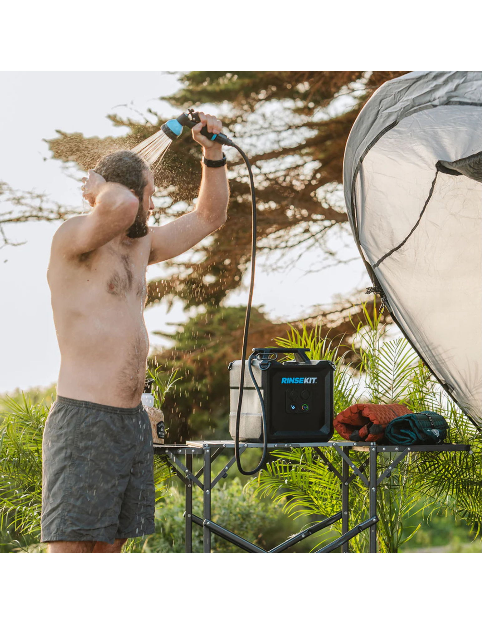 RinseKit Cube portable camping shower used for outdoor shower beside tent