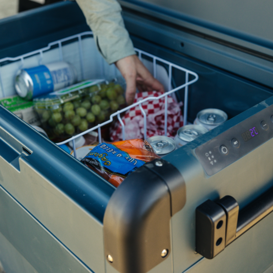Person reaching into a cooler filled with food and drinks