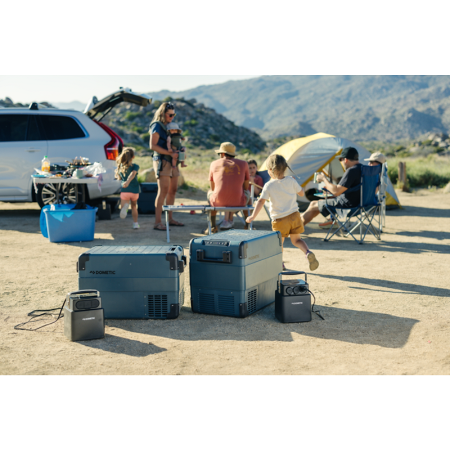 Group of people at a campsite with coolers and a generator.
