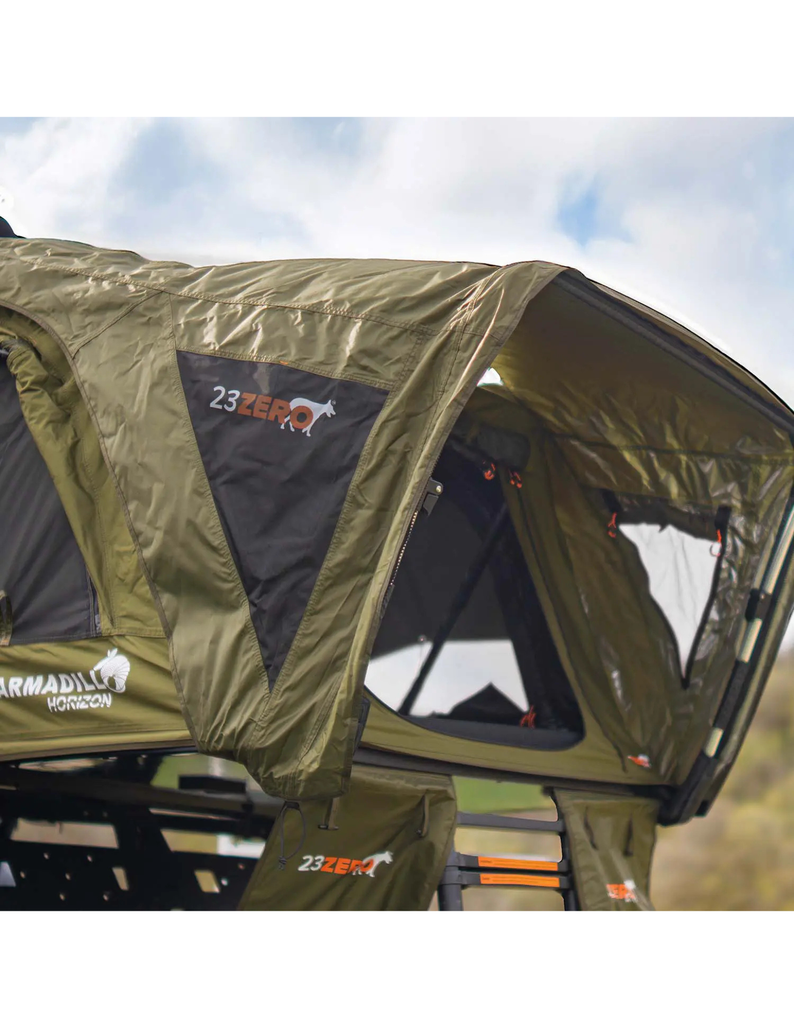 Green roof top tent with '23Zero' branding against a cloudy sky.