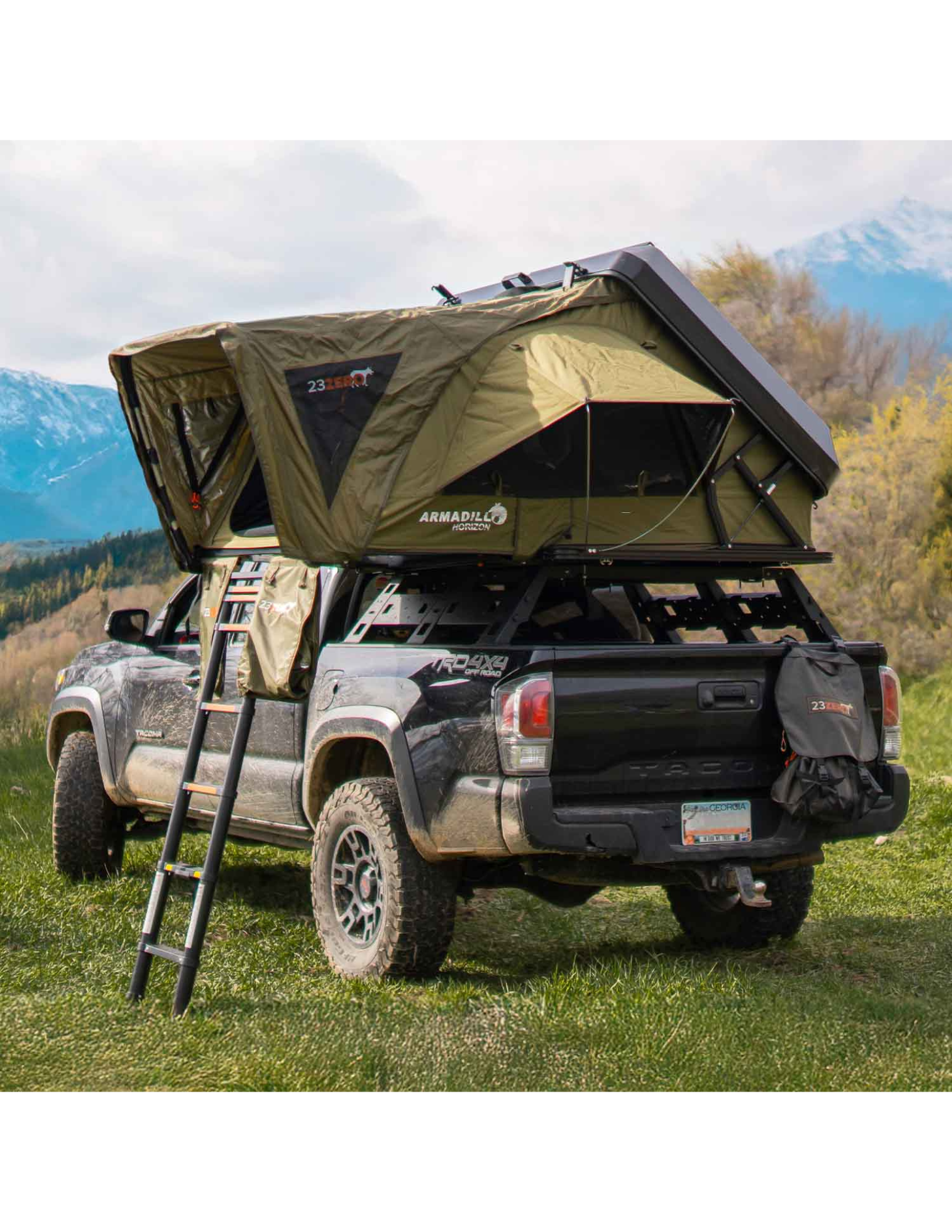 Green rooftop tent on a black Tacoma truck with mountains in the background