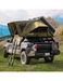 Green rooftop tent on a black Tacoma truck with mountains in the background