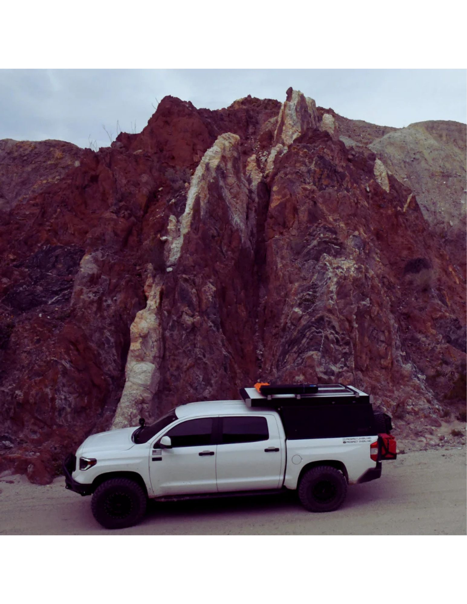 White overland truck with RinseKit rack shower mounted on roof rack in desert canyon