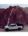 White overland truck with RinseKit rack shower mounted on roof rack in desert canyon