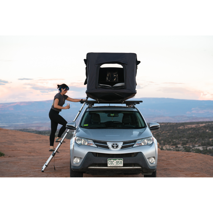 TentBox GO Rooftop Tent front view with person climbing ladder 