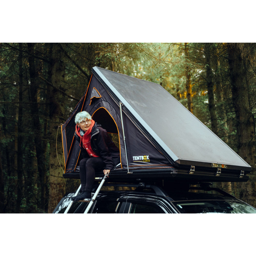 TentBox Cargo 1.0 Rooftop Tent front corner view with person sitting in tent