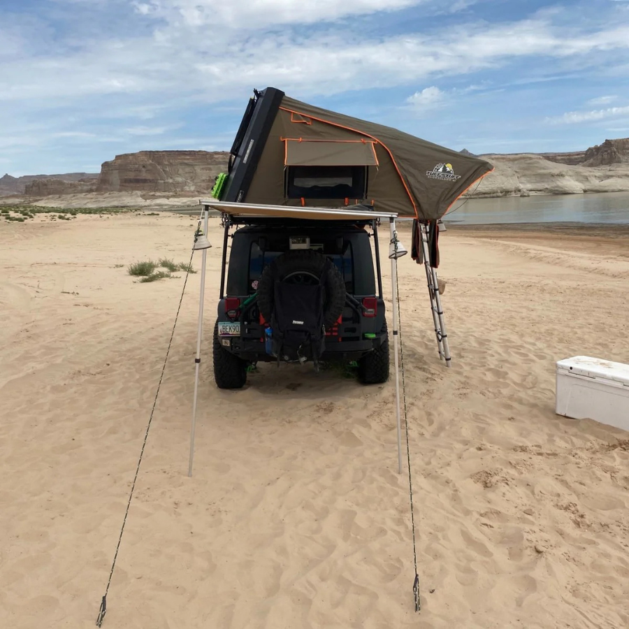 TUFF STUFF OVERLAND  STEALTH HARDSHELL ROOFTOP TENT, ALUMINUM, 3 PERSON, BLACK side view on jeep with awning out