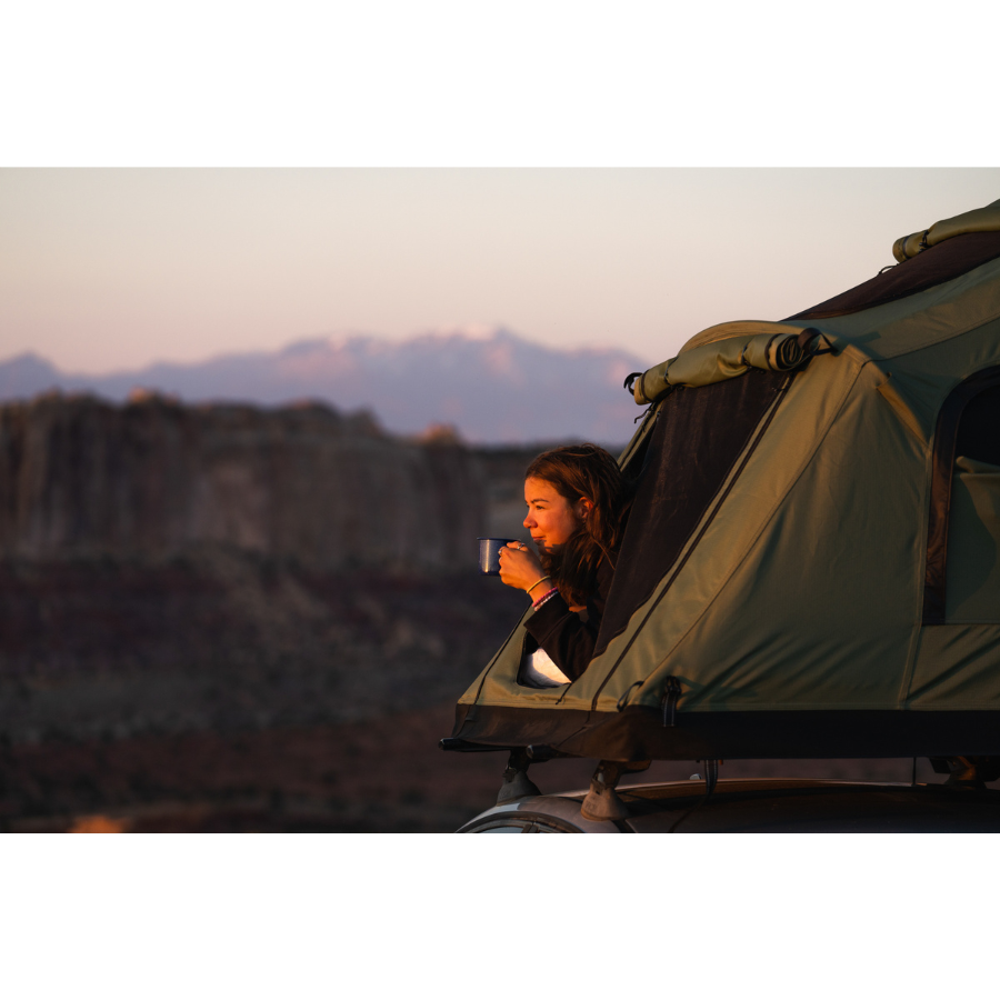 TentBox Lite 2.0 Rooftop Tent side view with person inside enjoying coffee